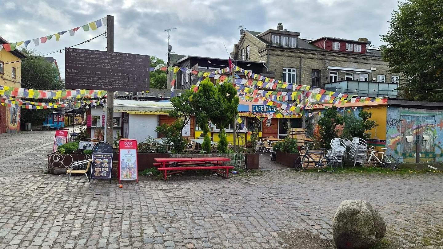 Praça de Christiania com bandeirinhas coloridas e café