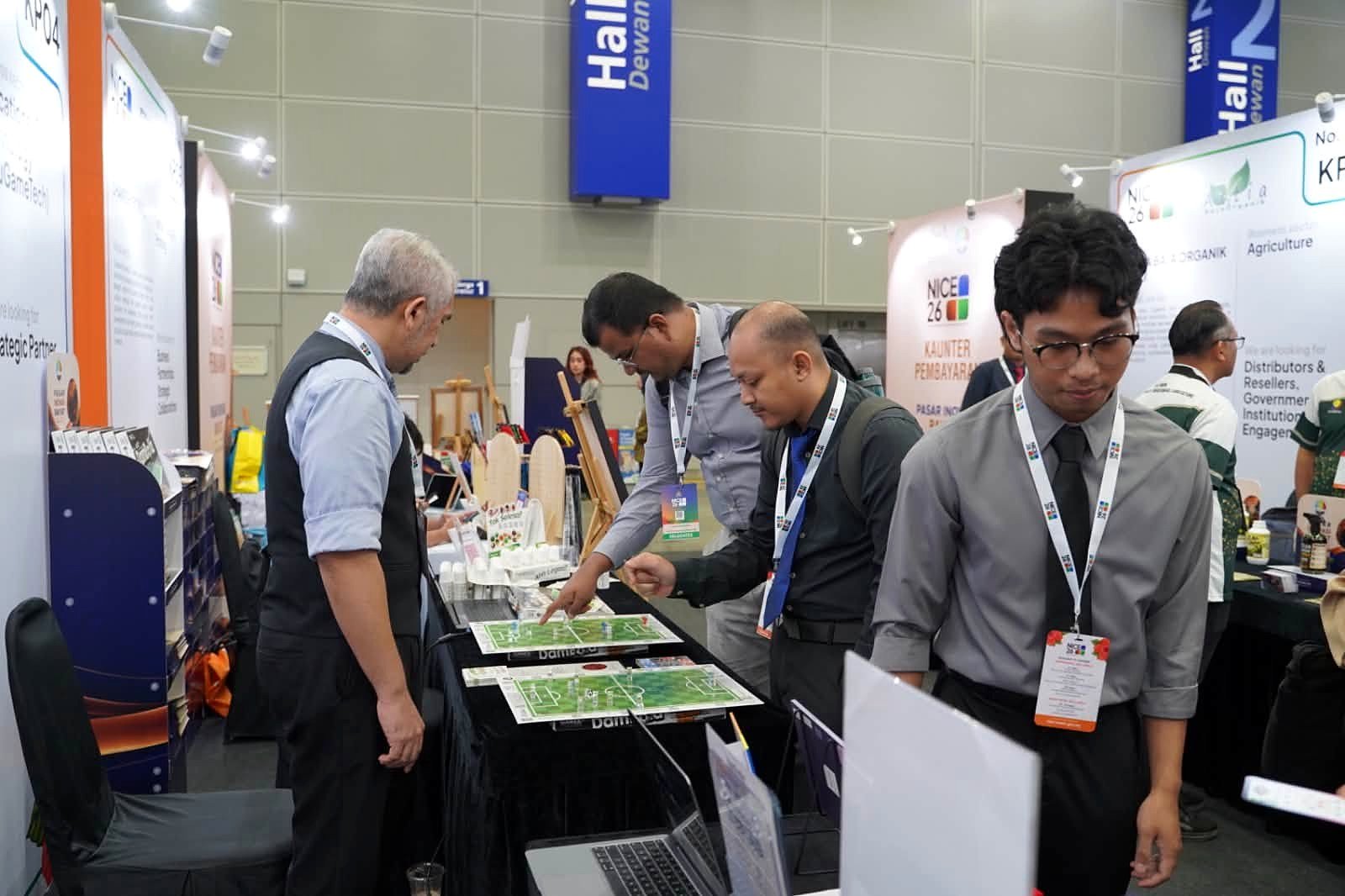 Visitantes conversando com expositores em estande de feira em Kuala Lumpur