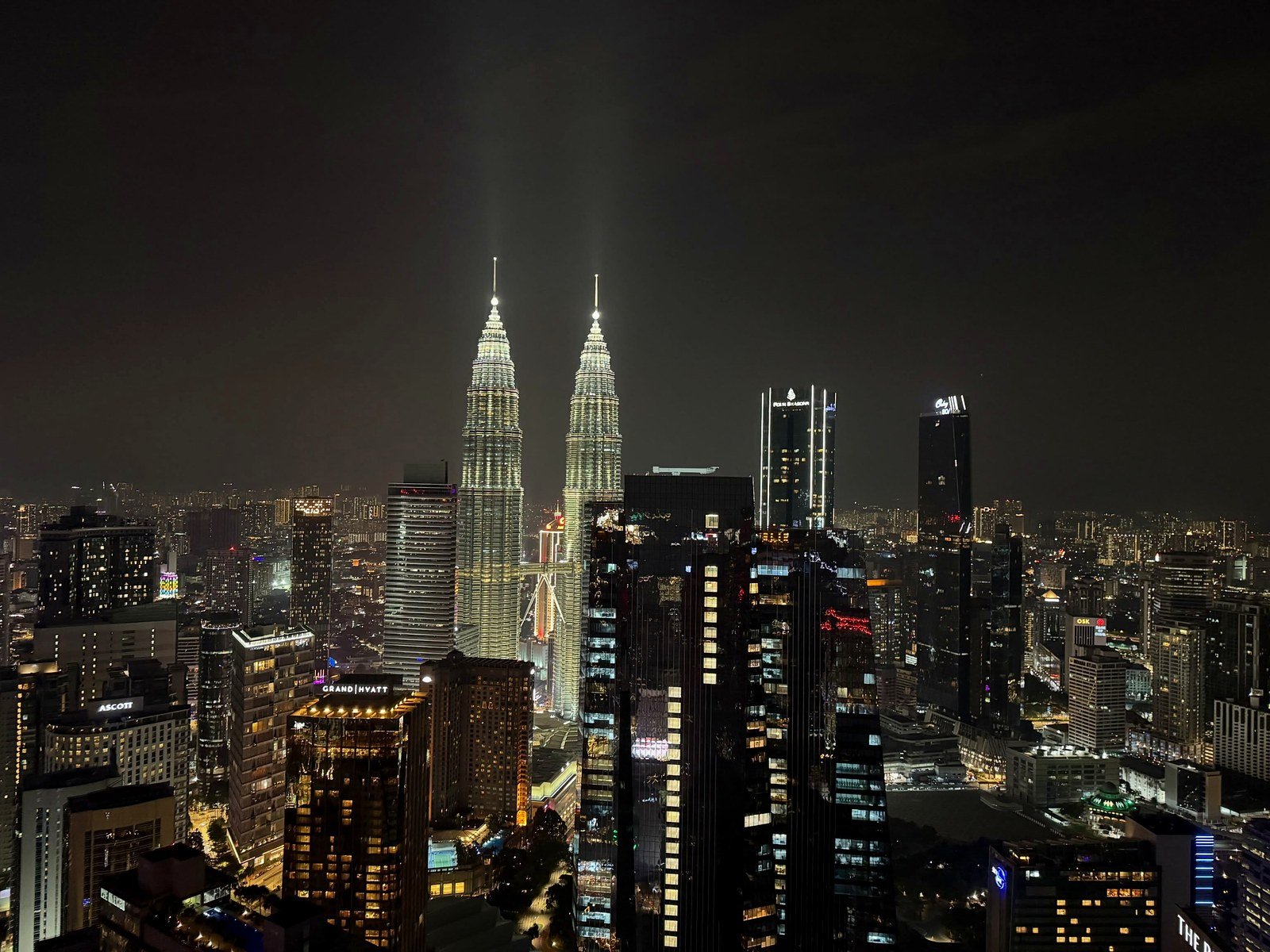 Torres Petronas e arranha-céus de Kuala Lumpur iluminados à noite