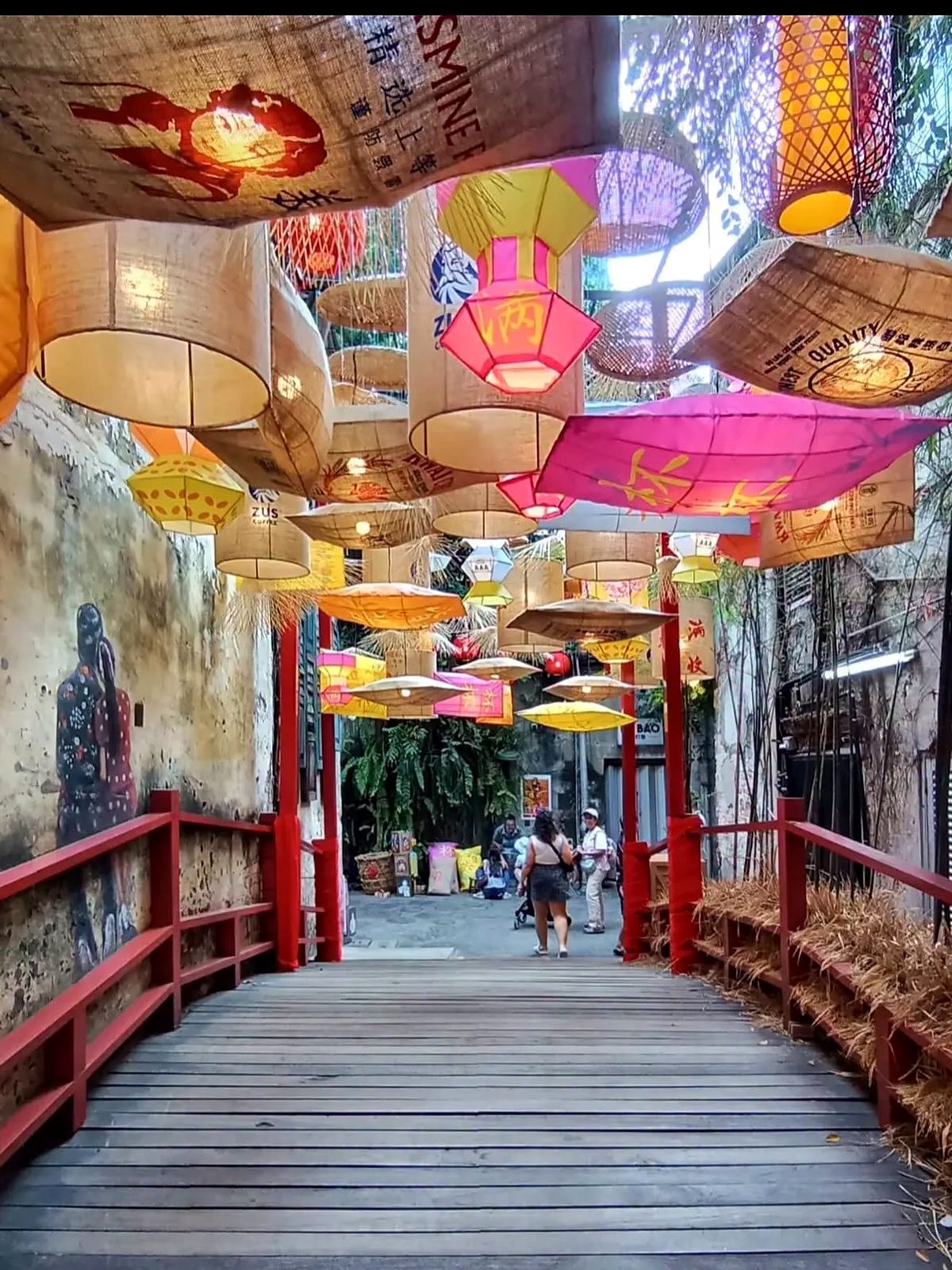 Passarela de madeira com lanternas coloridas em um beco histórico de Chinatown