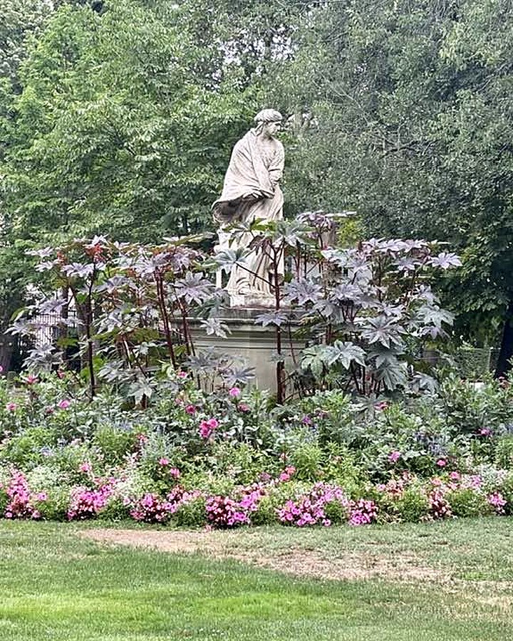 Estátua cercada de flores no Jardim de Luxemburgo