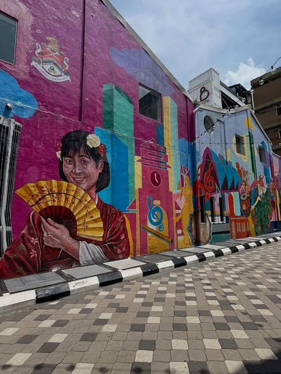 Mural colorido de mulher com leque em rua de Chinatown