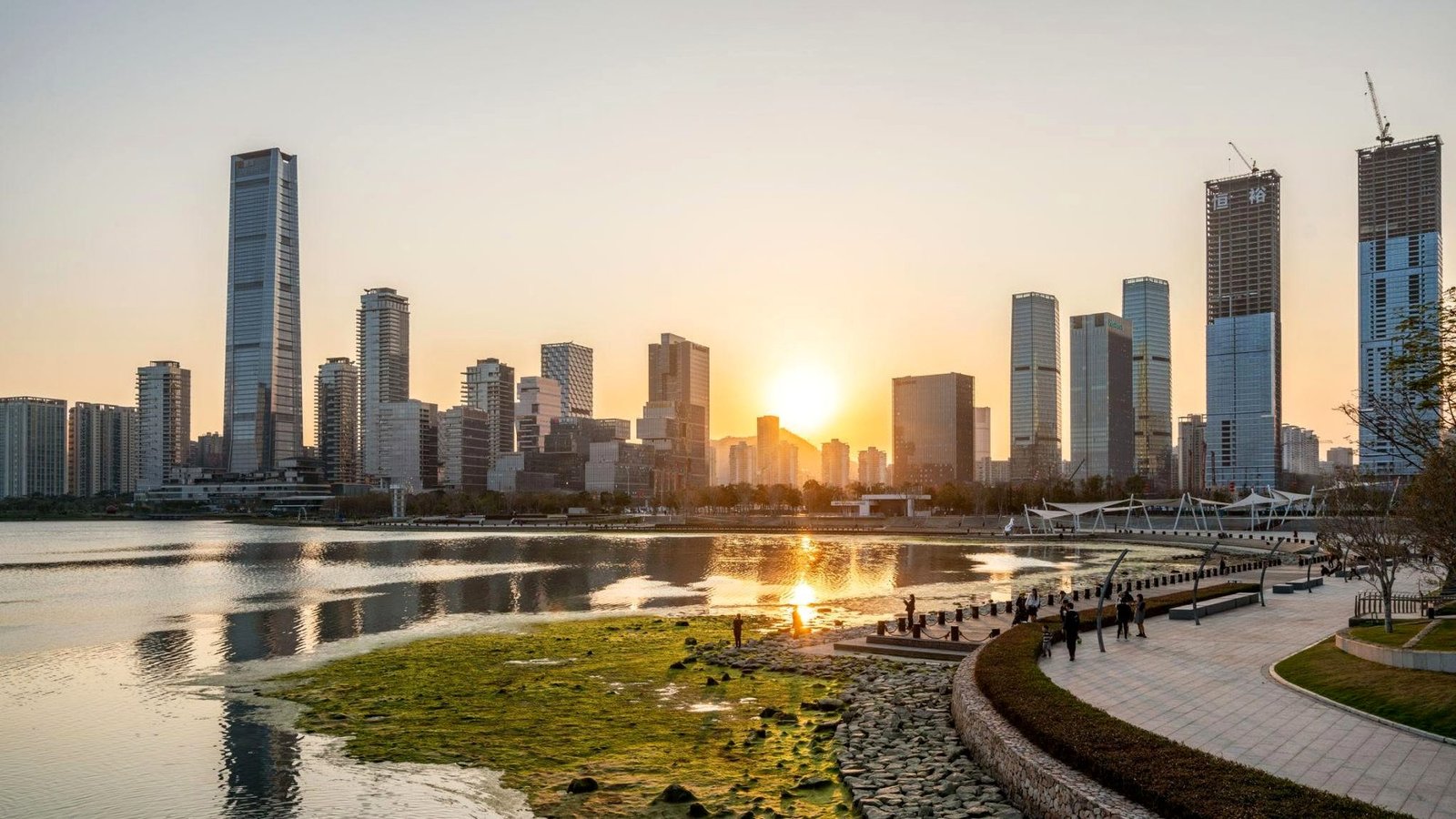 Vista panorâmica de Shenzhen ao pôr do sol, com os arranha-céus refletidos na baía