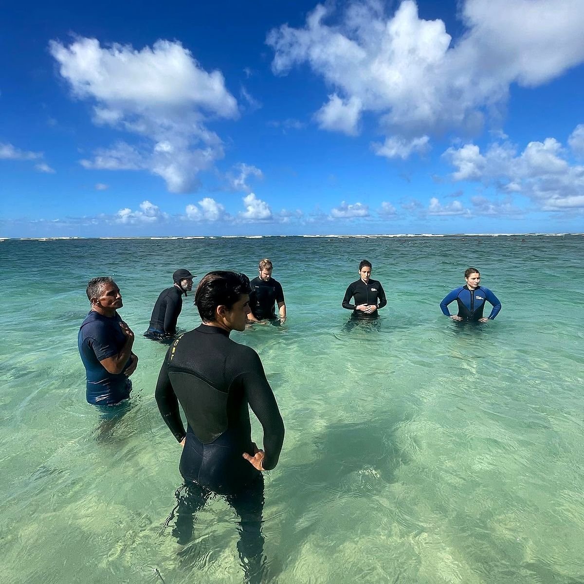 Alunos fazendo exercícios de respiração no mar cristalino do North Shore