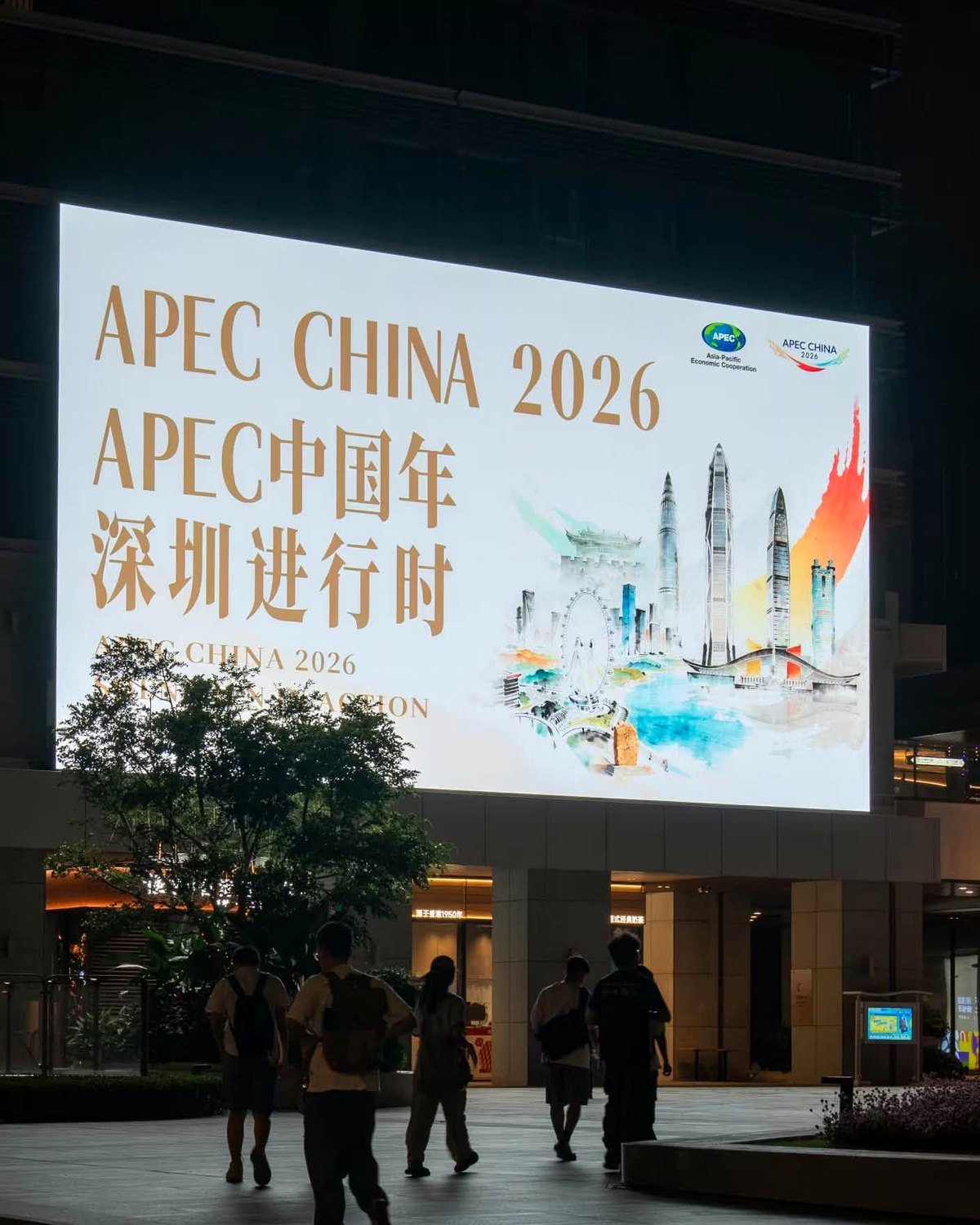 Painel luminoso do APEC China 2026 em uma praça de Shenzhen, à noite