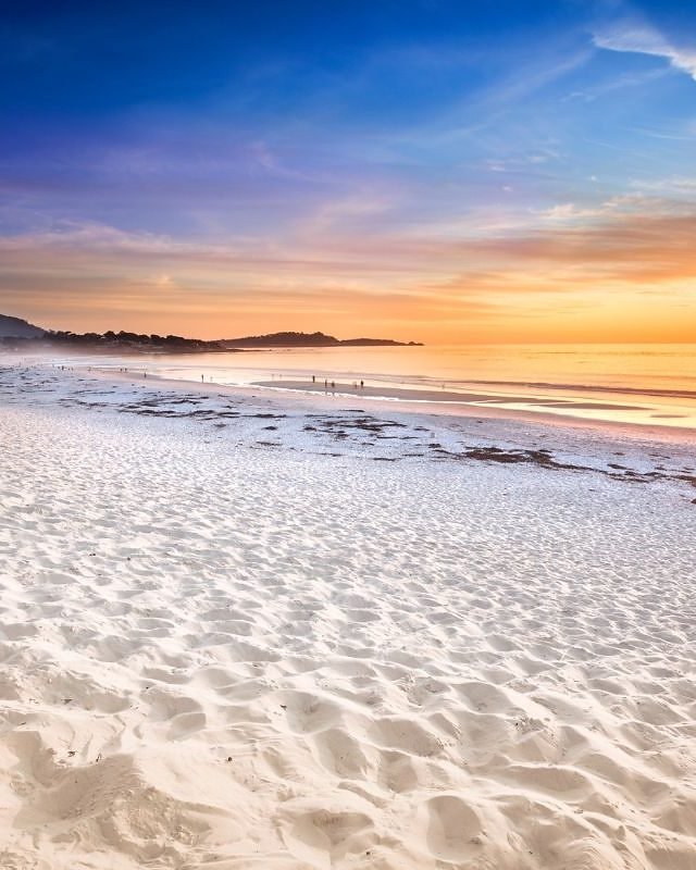Pôr do sol na Carmel Beach, com areia branca e ciprestes em Carmel By The Sea, Califórnia