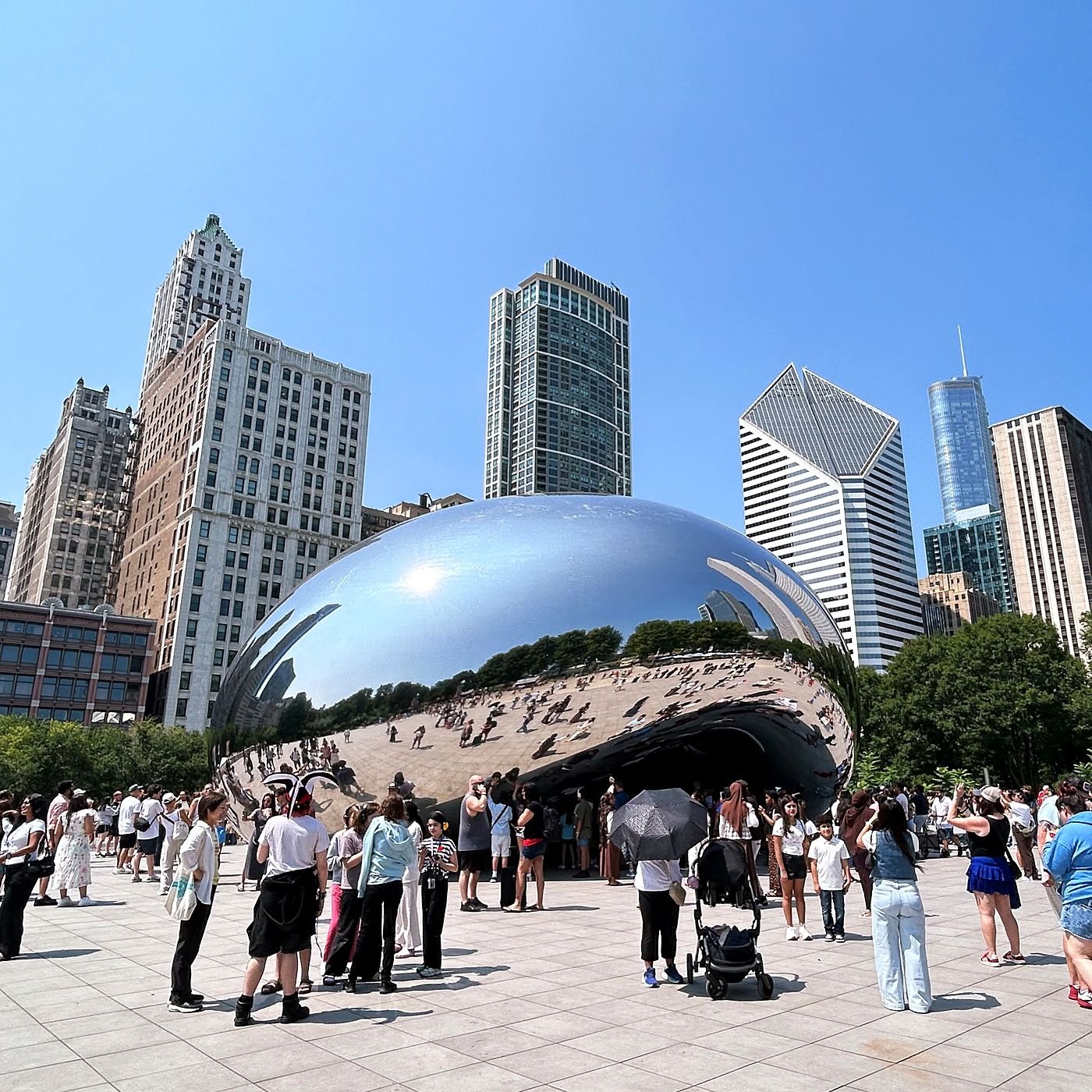 Visitantes em volta da escultura Cloud Gate, no Millennium Park, em dia de verão