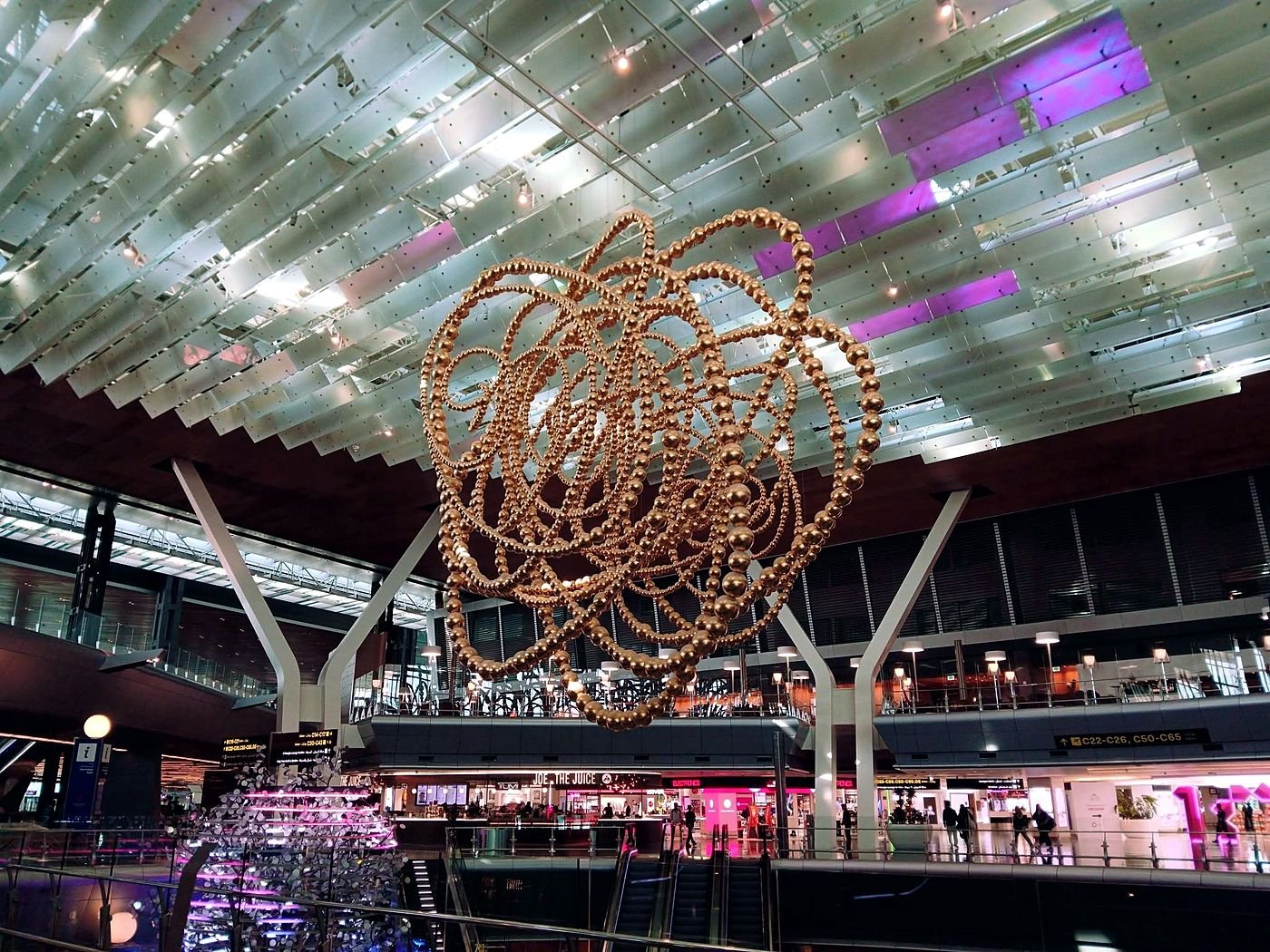 Escultura dourada suspensa no saguão do Aeroporto Internacional Hamad