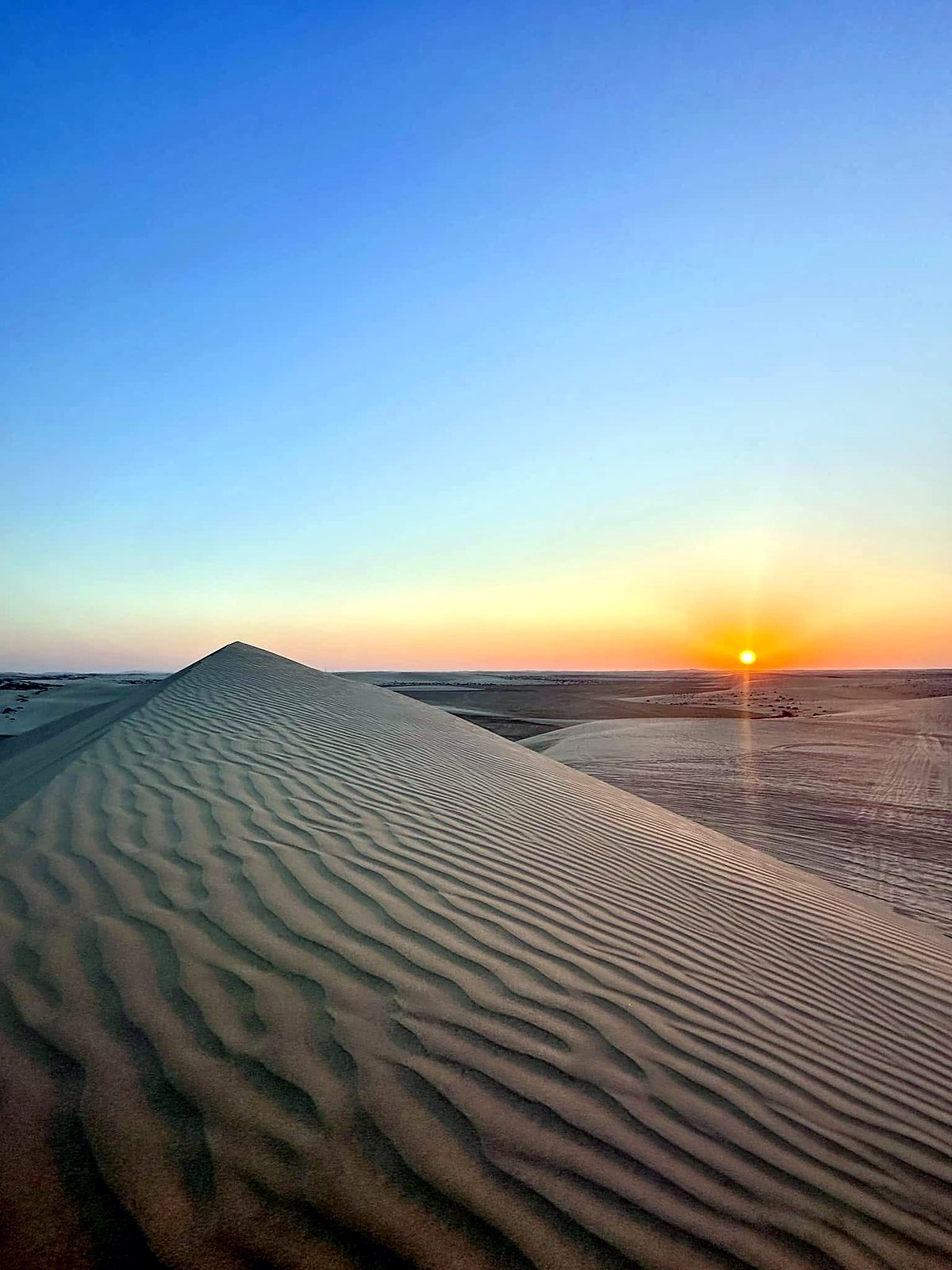 Duna de areia no deserto do Catar ao pôr do sol