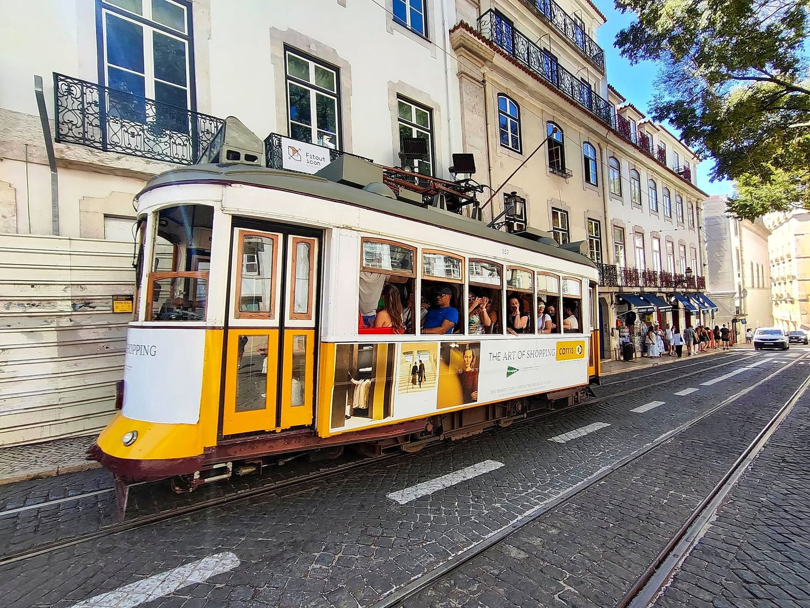 Elétrico amarelo em uma rua histórica de Lisboa