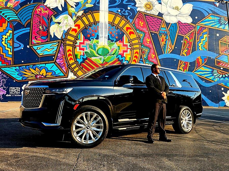 SUV Cadillac Escalade preta em frente a um mural colorido em Dallas