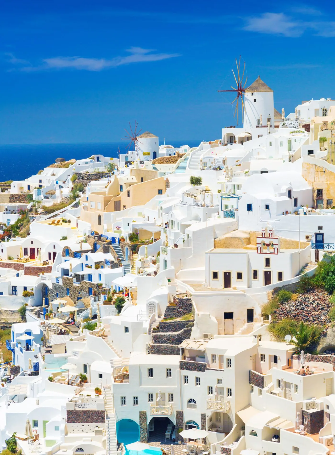Casas brancas, cúpulas e moinhos de vento de Oia, em Santorini, sobre a caldeira