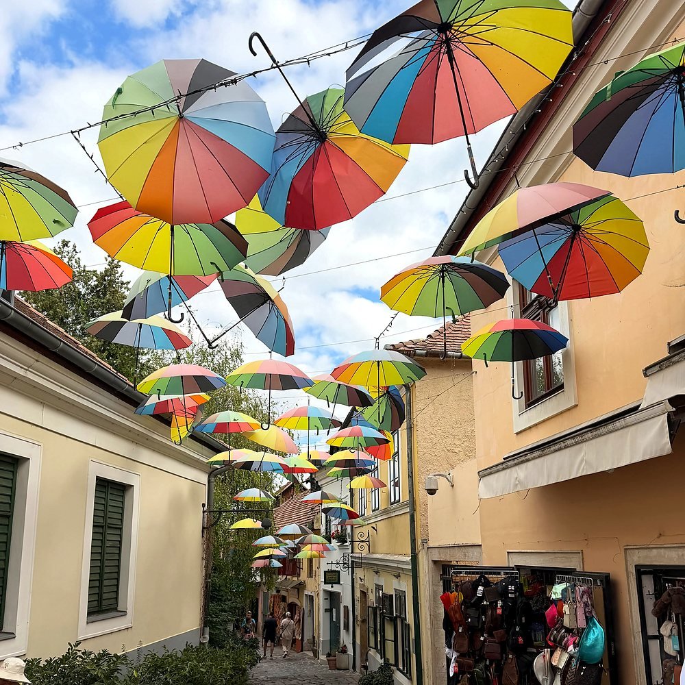 Rua de pedra com guarda-chuvas coloridos em Szentendre