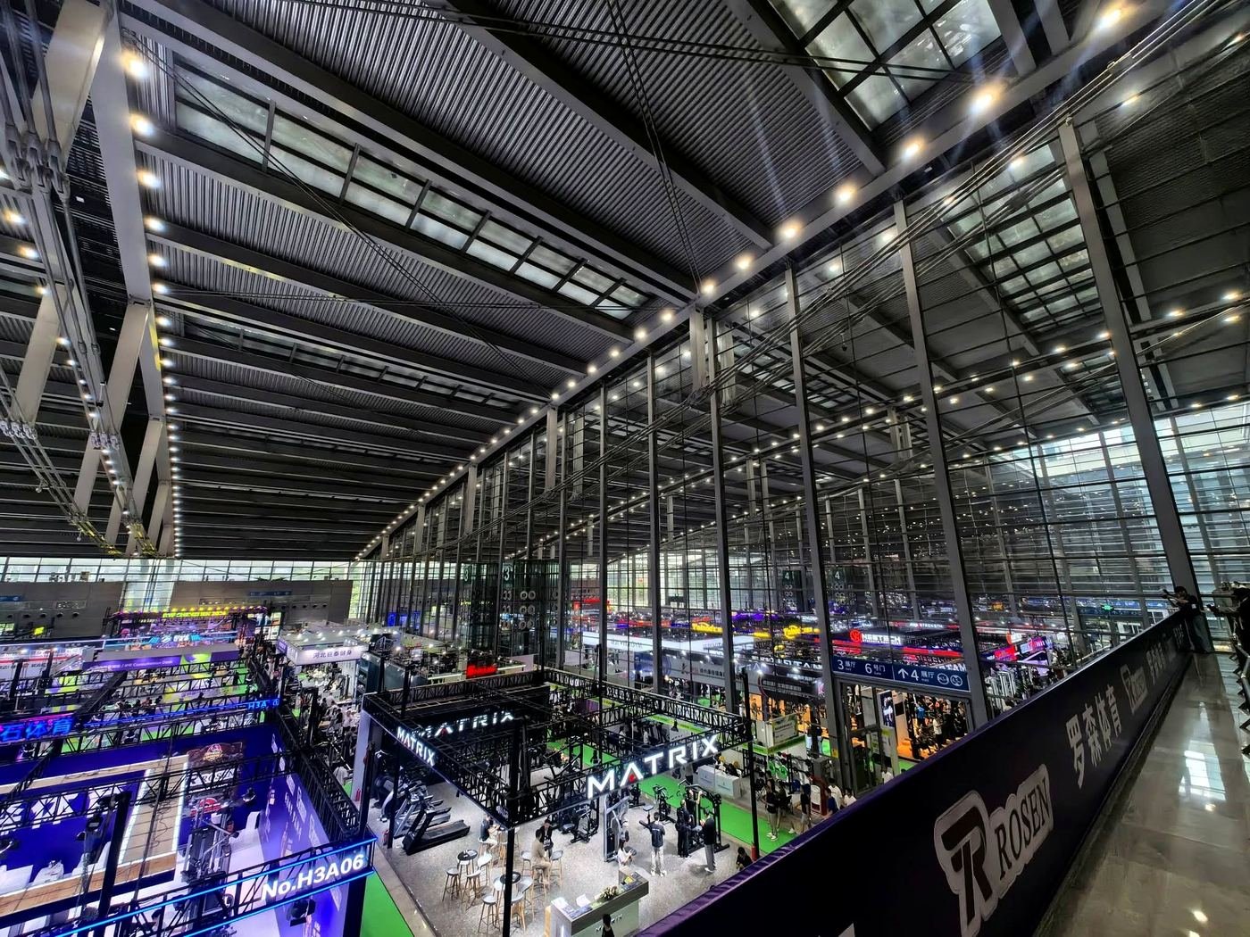 Vista interna de um pavilhão de feira em Shenzhen, com estandes iluminados e corredores largos