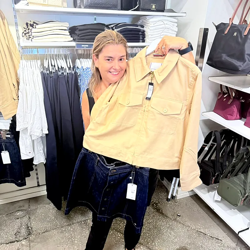 Débora mostrando uma peça de roupa dentro de uma loja em outlet de Orlando