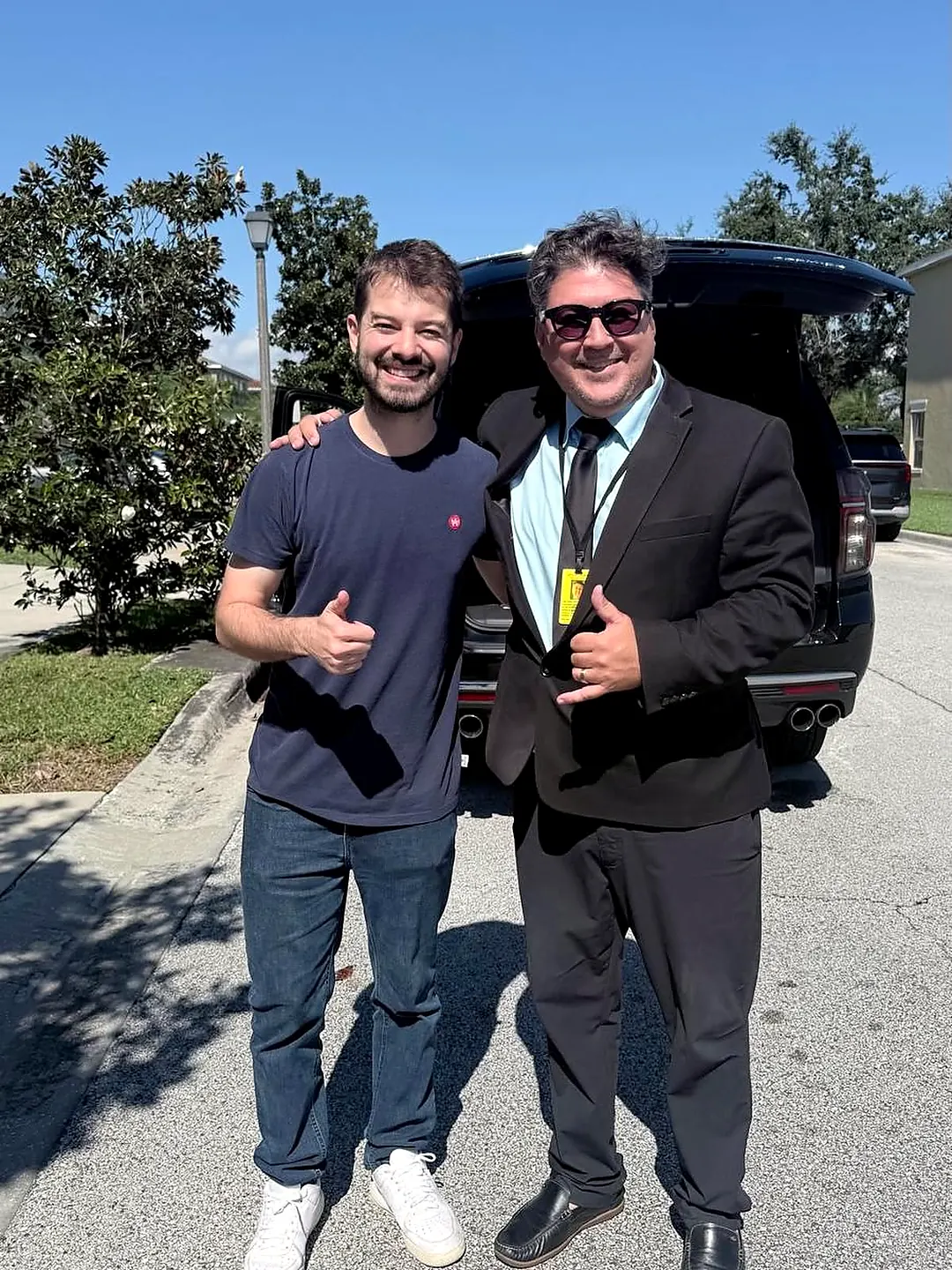 Marcelo, da 1001 Transportation, ao lado de um cliente e do veículo executivo em Orlando