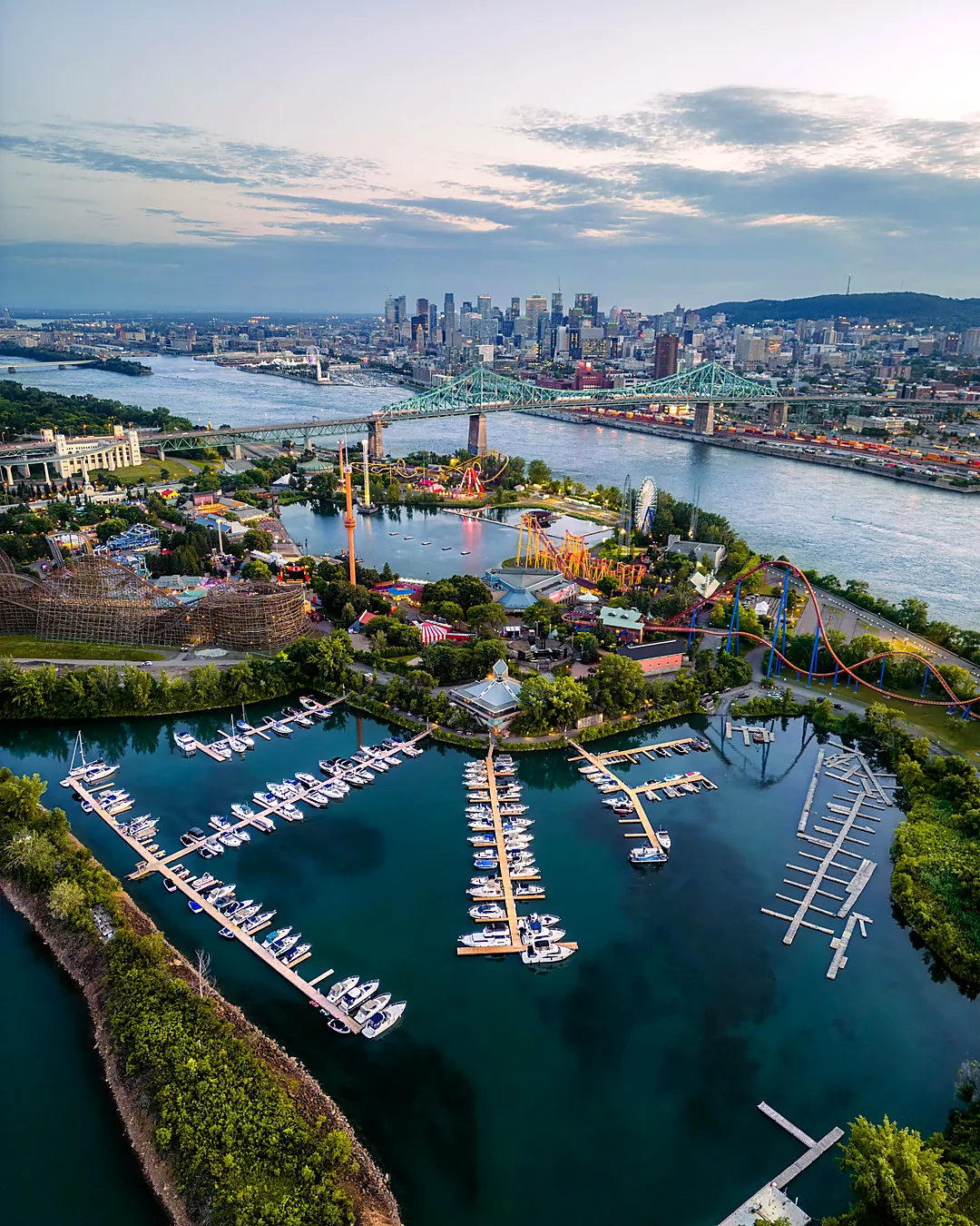 Vista aérea de Montreal ao entardecer, com a ponte Jacques-Cartier sobre o rio São Lourenço, o centro e o Mont Royal ao fundo
