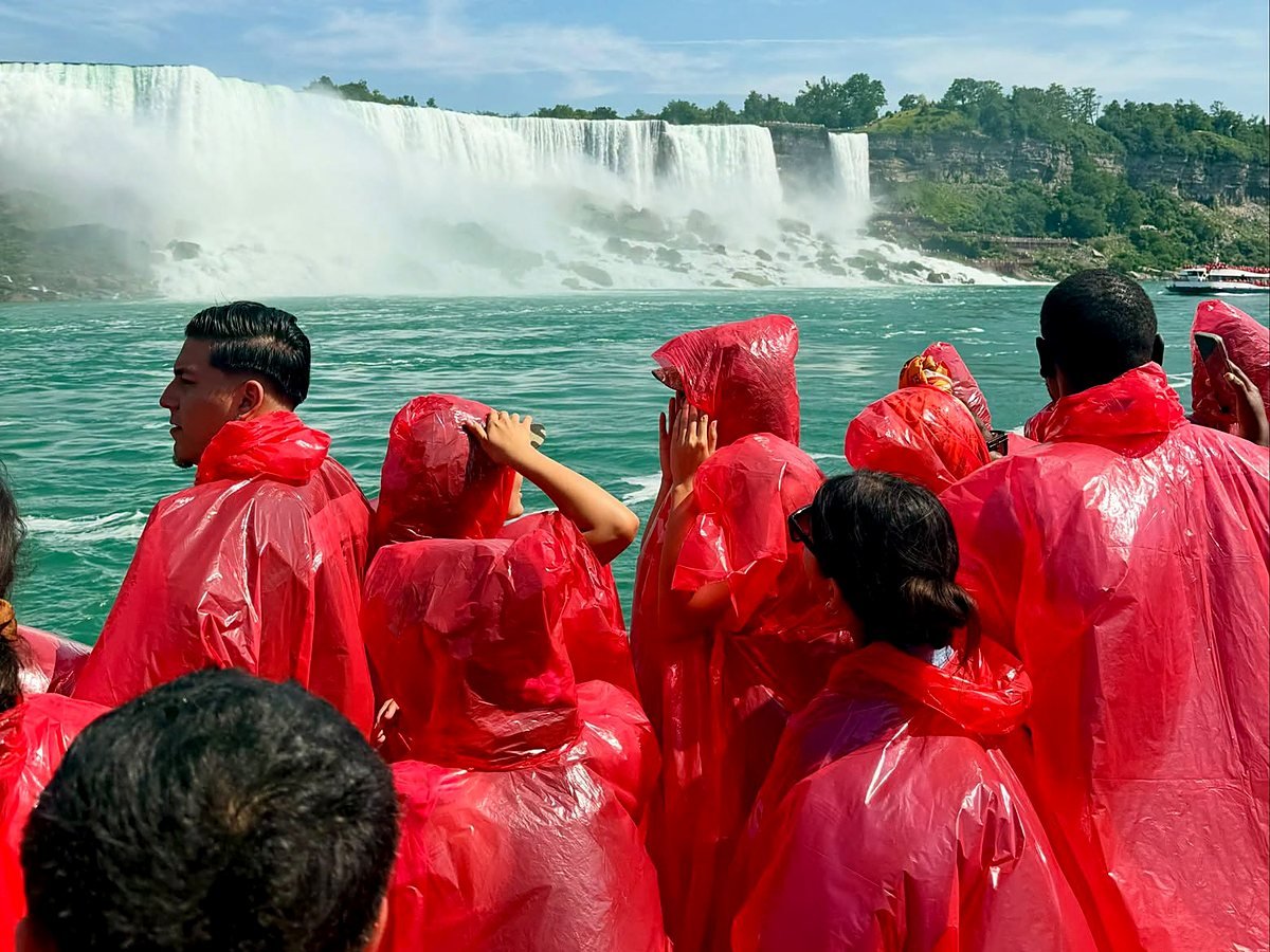 Passageiros de capa vermelha no barco diante das Cataratas Americanas
