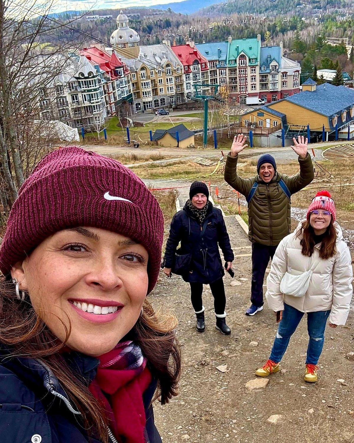 Leila Diniz com clientes na montanha, com o vilarejo colorido de Mont Tremblant ao fundo