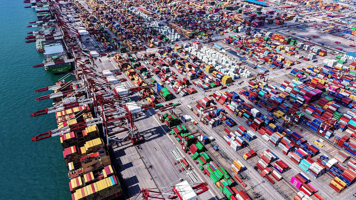 Porto de contêineres na China com navios de carga e guindastes