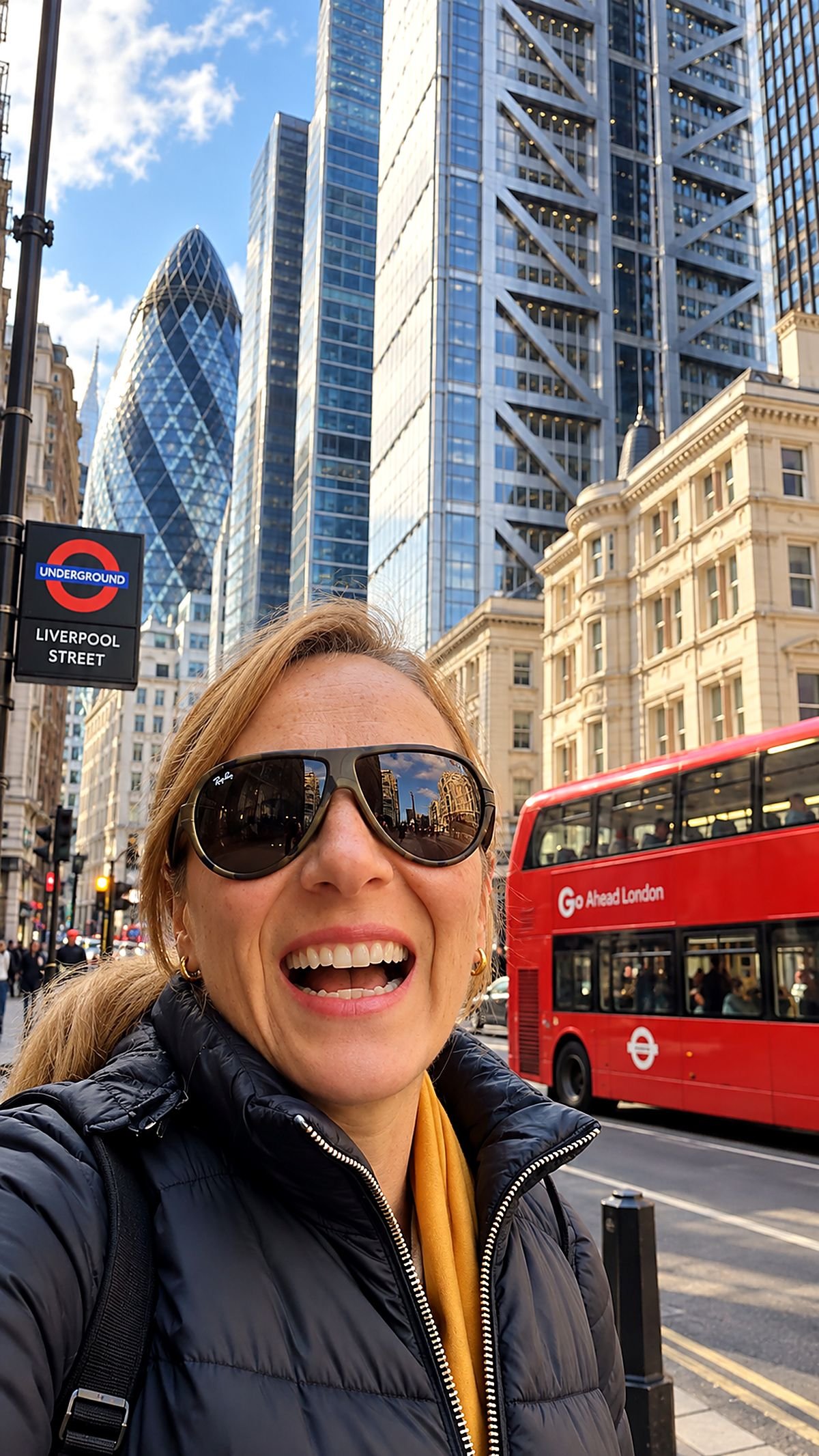 Rita Castelan em Liverpool Street, na City de Londres, com um ônibus vermelho e o edifício Gherkin ao fundo