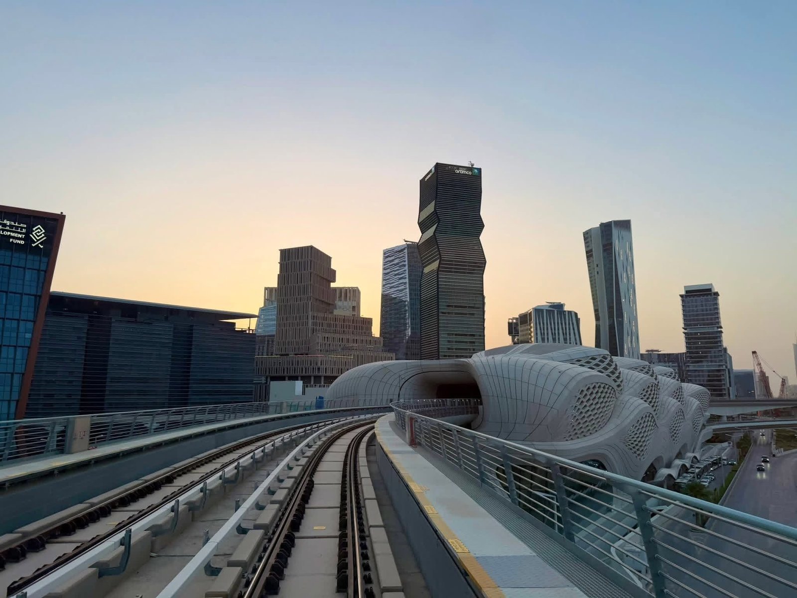 Trilhos elevados do metrô de Riade e torres do KAFD ao entardecer