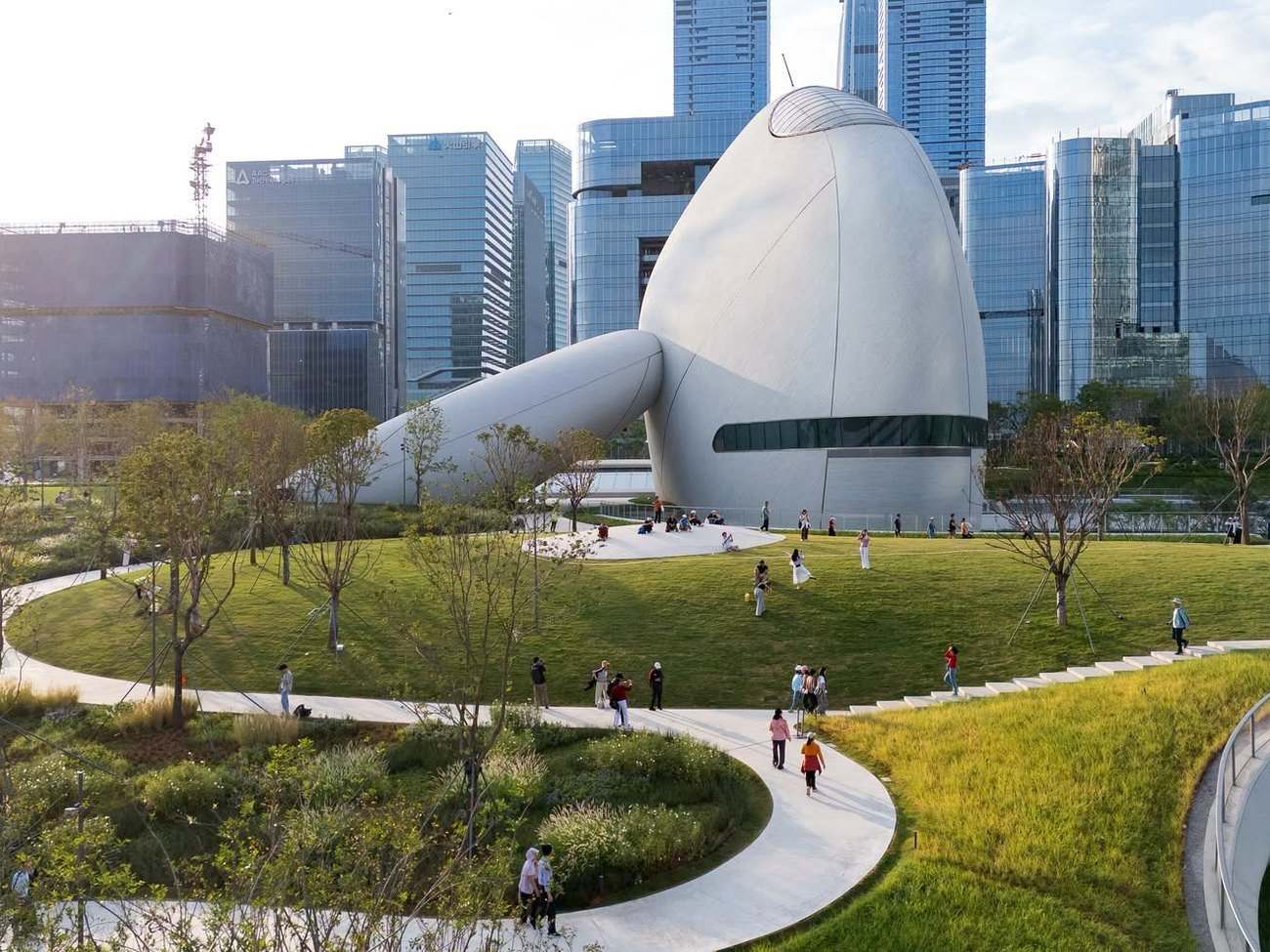 Parque urbano de Shenzhen com prédio de arquitetura moderna e caminhos gramados