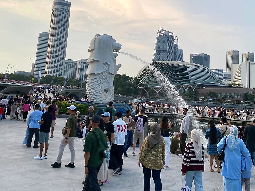 Merlion em frente à baía, com o teatro Esplanade ao fundo
