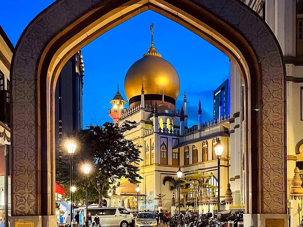 Mesquita do Sultão vista através de um arco, ao entardecer