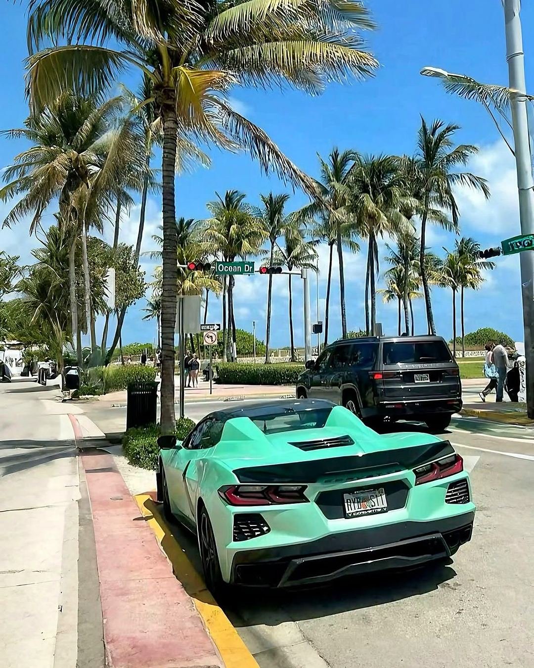 Ocean Drive, em Miami Beach, com palmeiras e carro esportivo estacionado