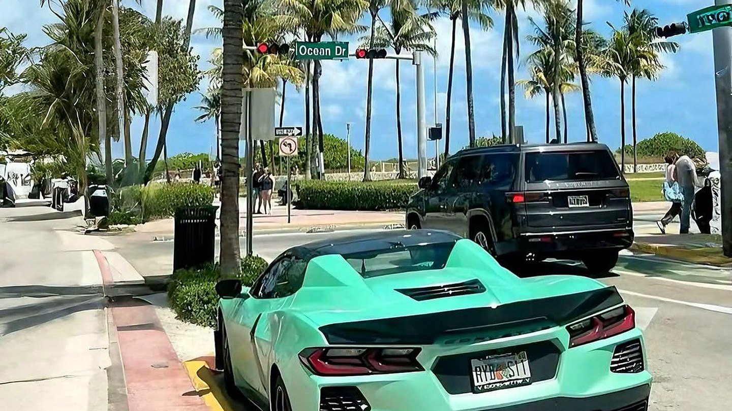 Ocean Drive, em Miami Beach, com palmeiras e carro esportivo estacionado