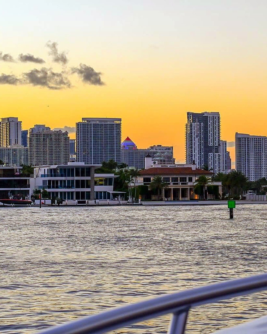 Skyline de Fort Lauderdale ao pôr do sol, visto da água, com prédios e casas à beira do canal