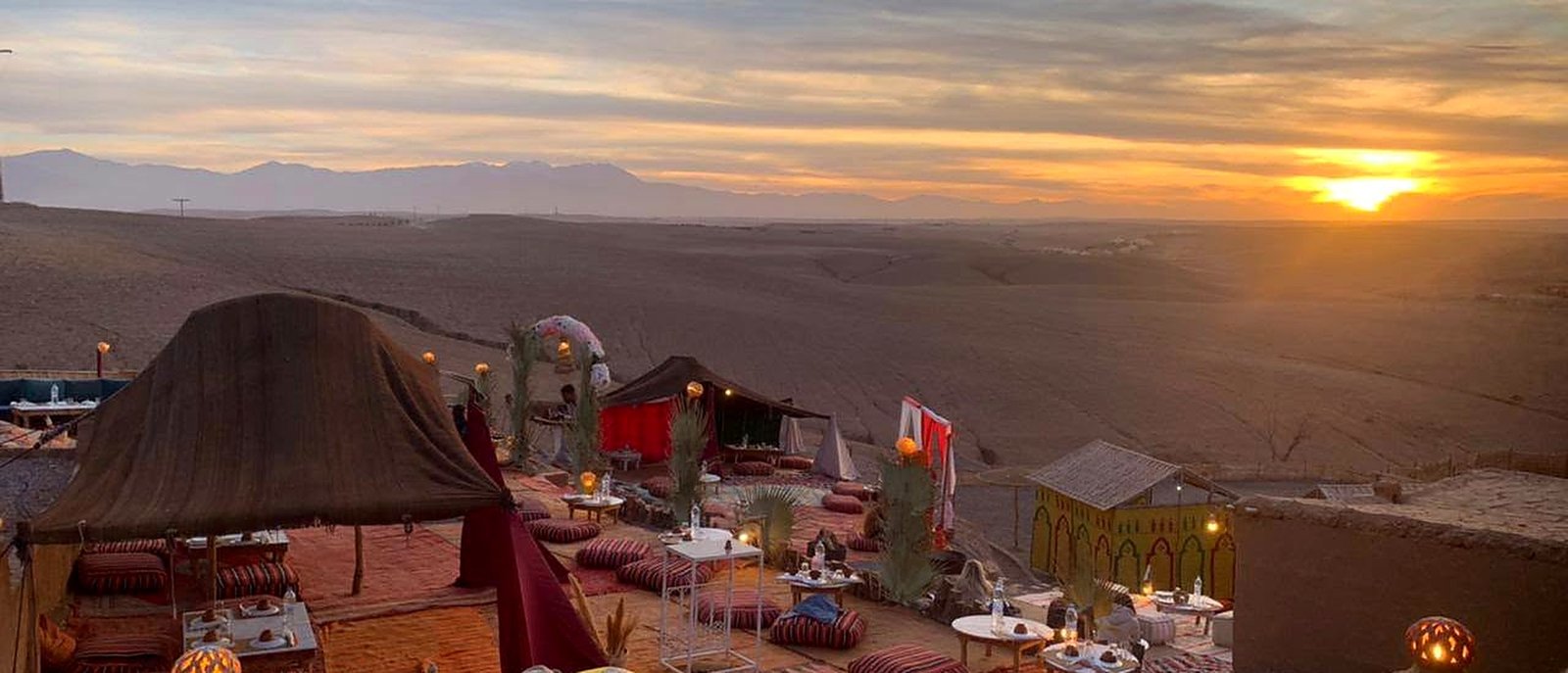 Jantar em acampamento berbere ao pôr do sol no Deserto de Agafay, com as Montanhas do Atlas ao fundo