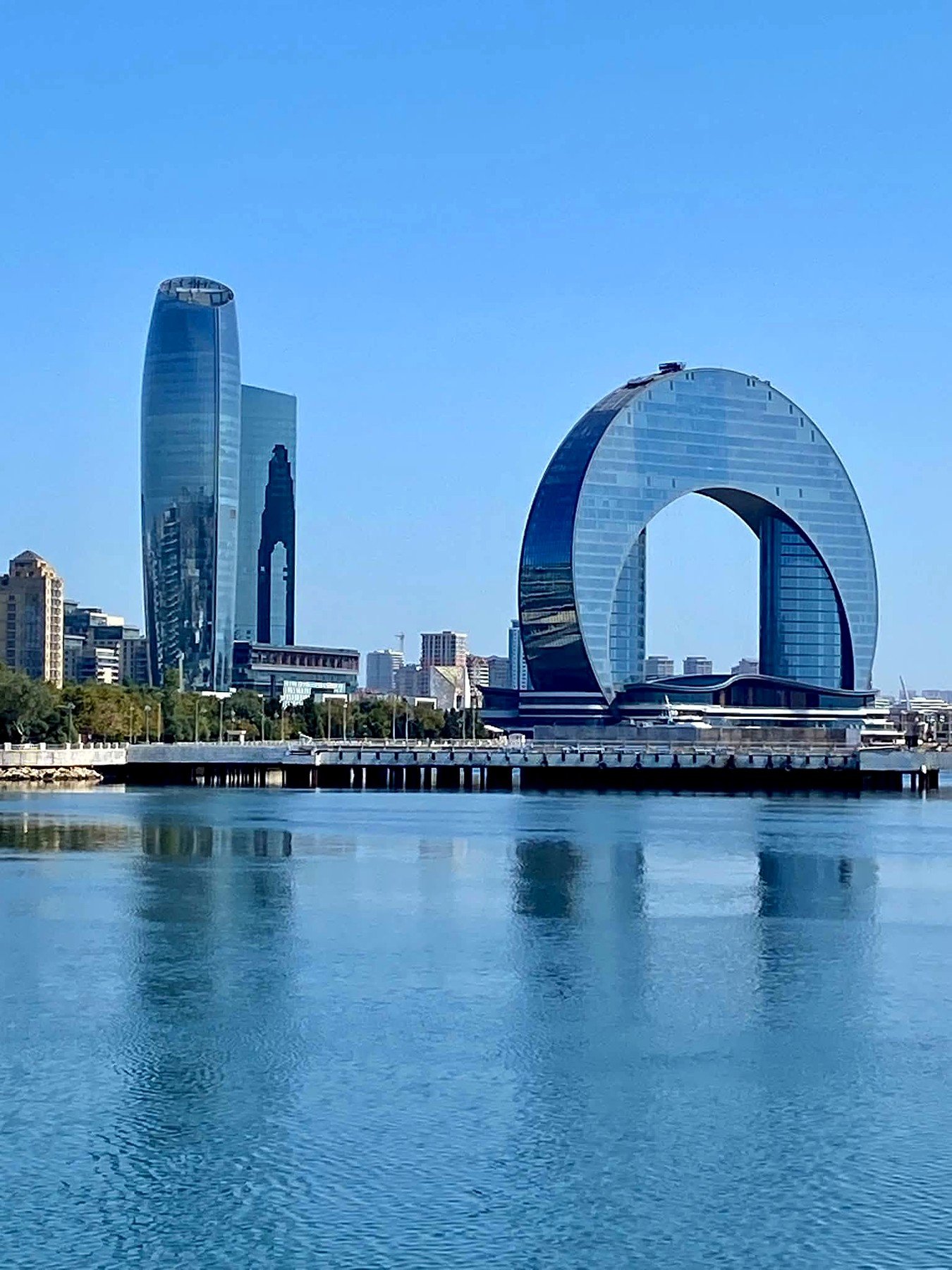 Baku Bulvar na orla do Mar Cáspio com o edifício em forma de meia-lua