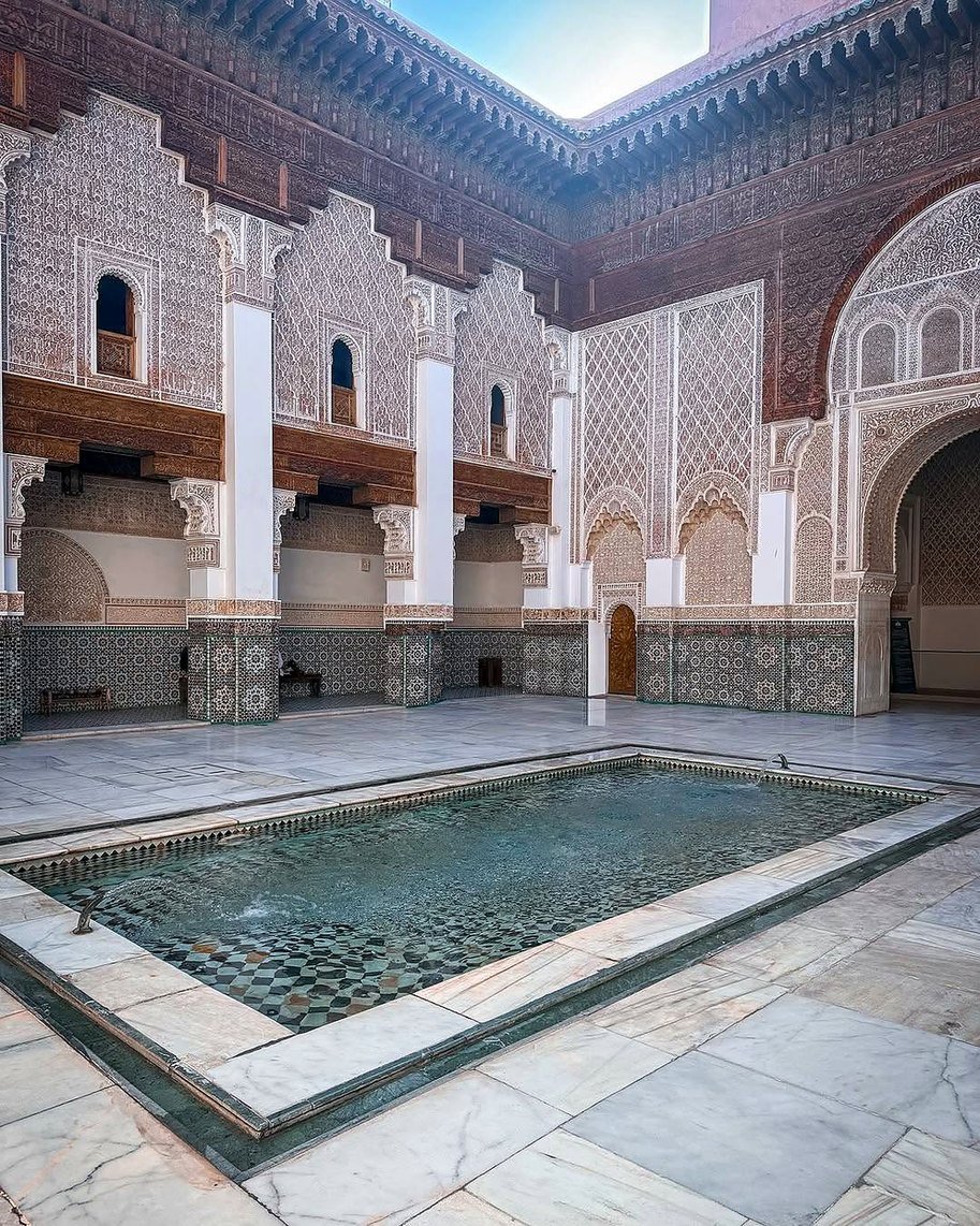 Pátio da Madrasa Ben Youssef com espelho d'água e paredes de estuque esculpido