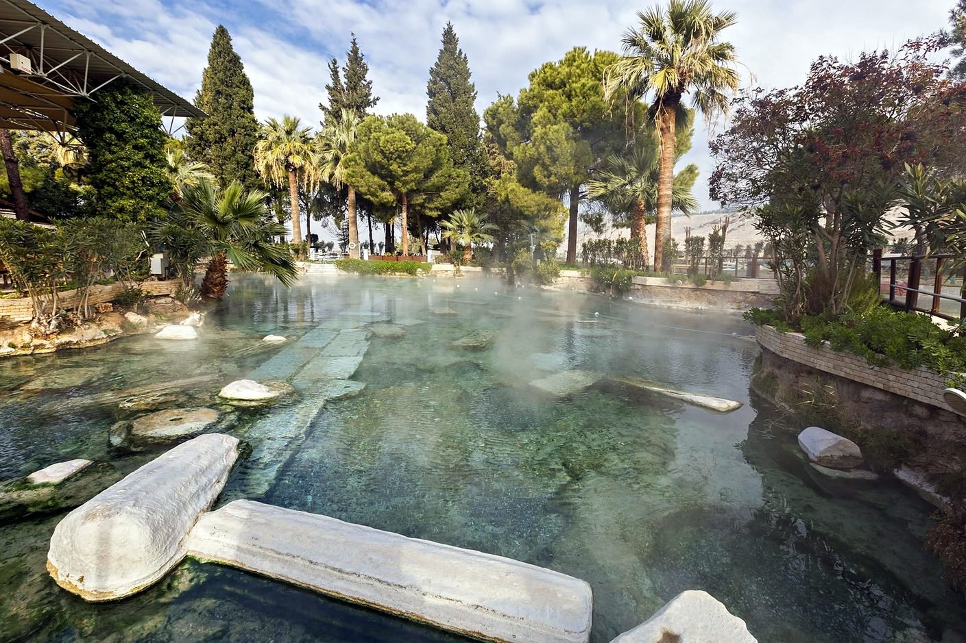 Piscina de Cleópatra em Pamukkale com colunas antigas submersas e vapor sobre a água