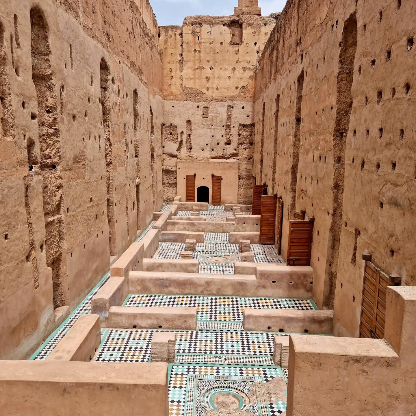Pavilhões com piso de mosaico entre as muralhas do Palácio El Badi em Marrakech
