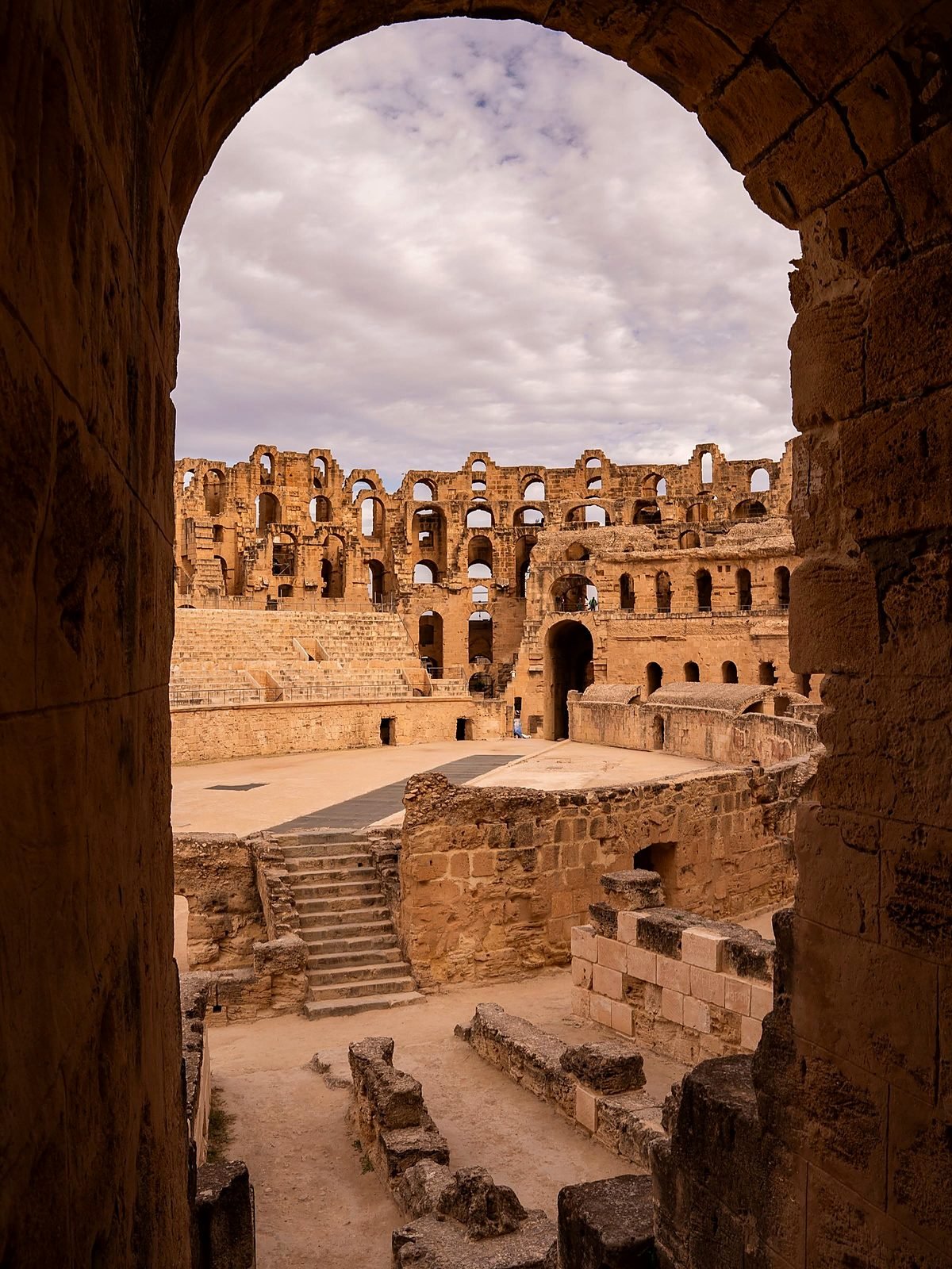 Arena e galerias subterrâneas do Anfiteatro de El Jem vistas por um arco
