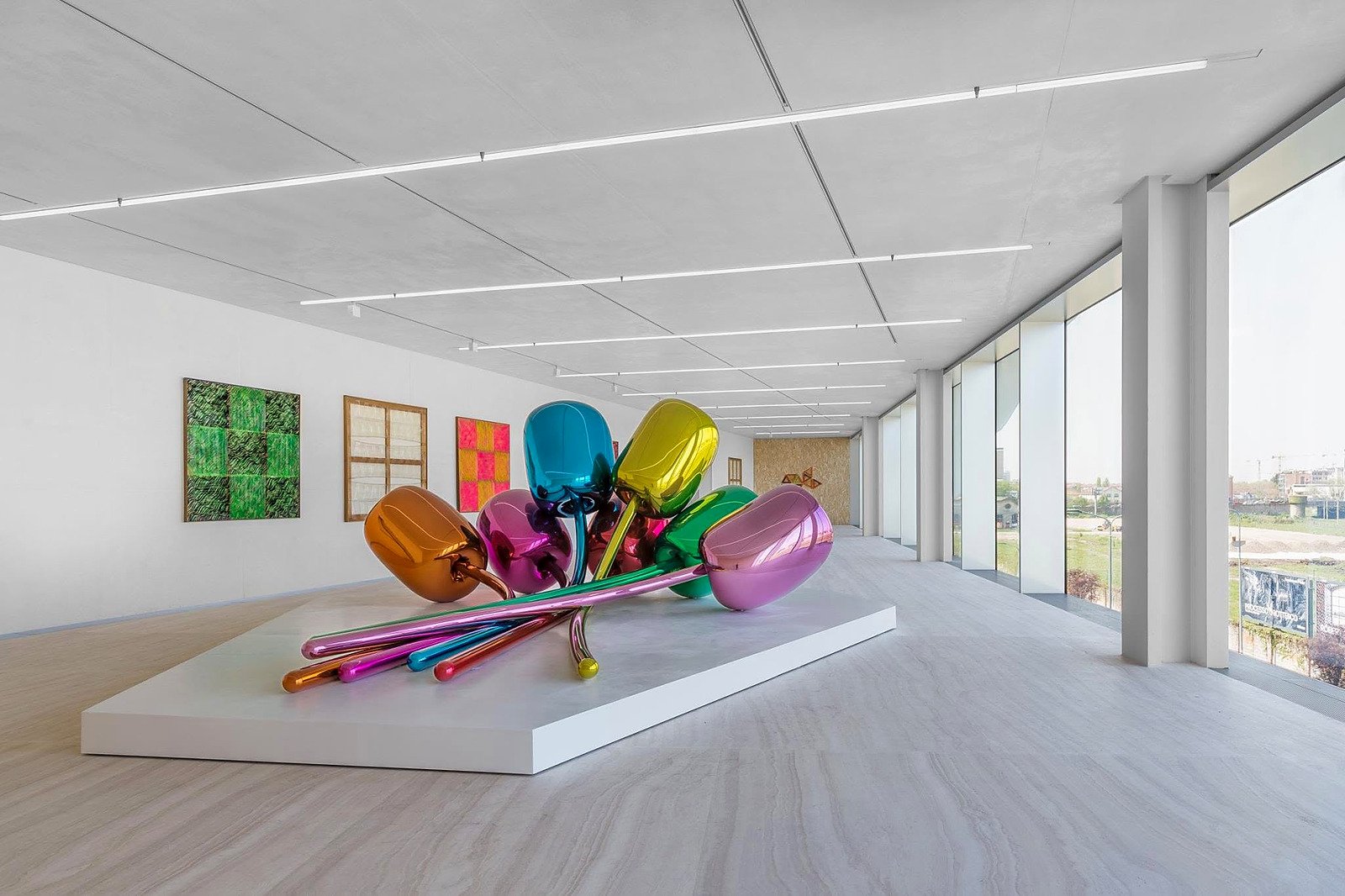Sala de exposição da Fondazione Prada em Milão com escultura de tulipas coloridas