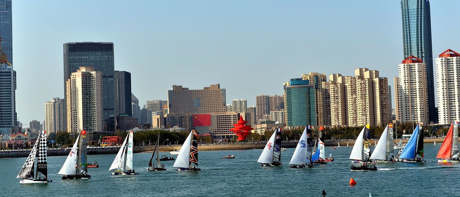 Regata na Baía de Fushan com o skyline de Qingdao ao fundo