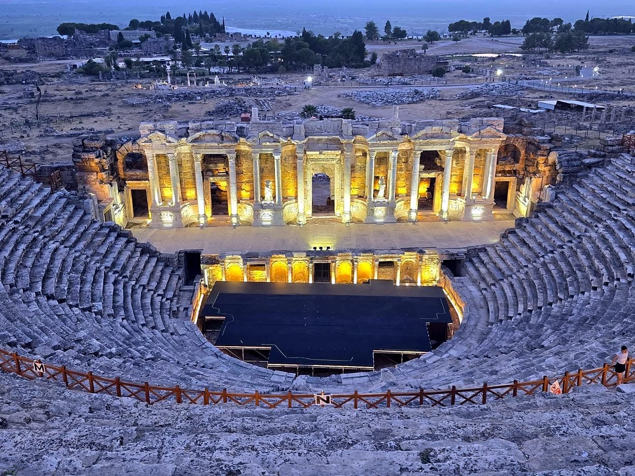 Teatro romano de Hierápolis iluminado ao entardecer, com a planície ao fundo