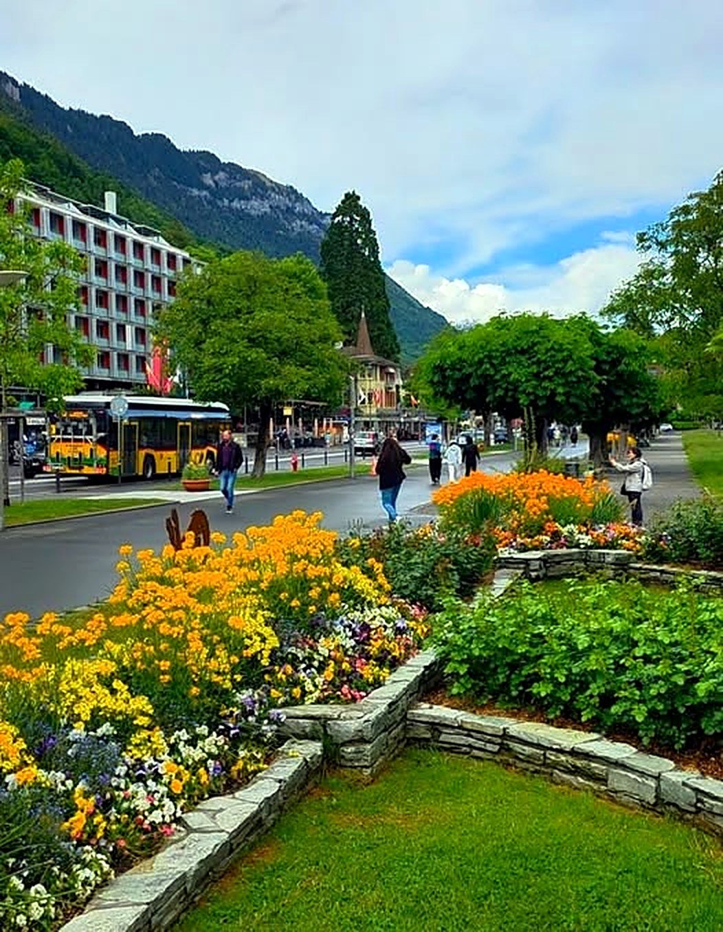 Canteiros floridos na avenida principal de Interlaken com montanhas ao fundo