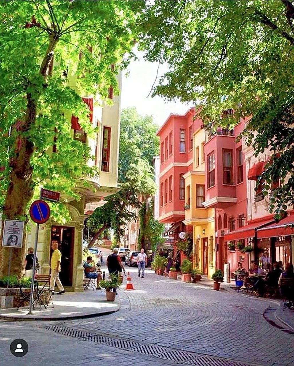 Rua arborizada com casas coloridas e cafés no lado asiático de Istambul