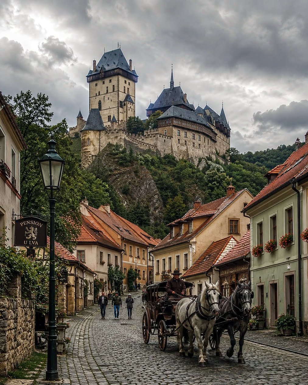 Castelo de Karlštejn no alto da colina sobre a vila, com carruagem na rua de pedra