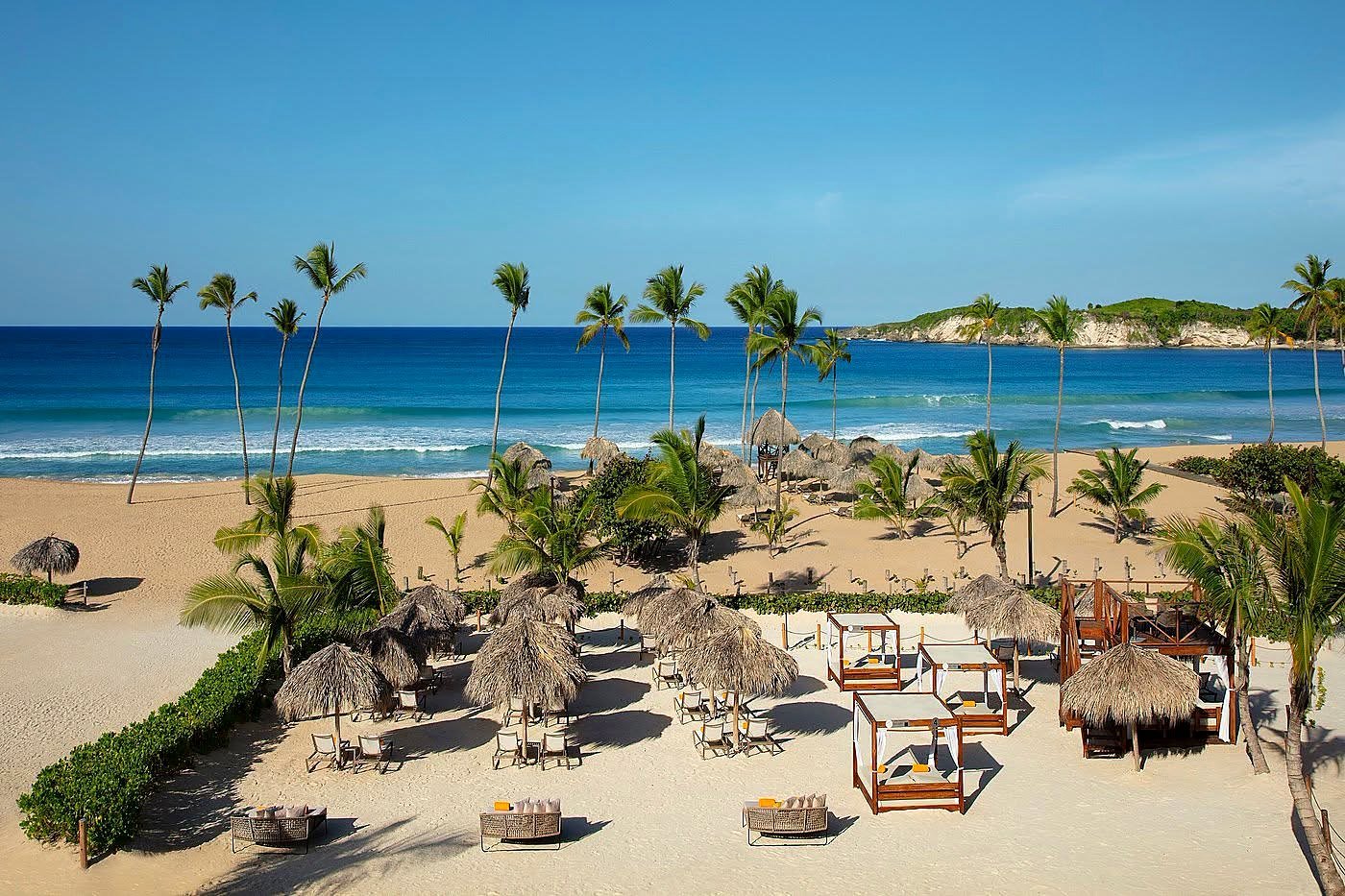 Praia de Macao em Punta Cana com coqueiros, ondas e falésia verde