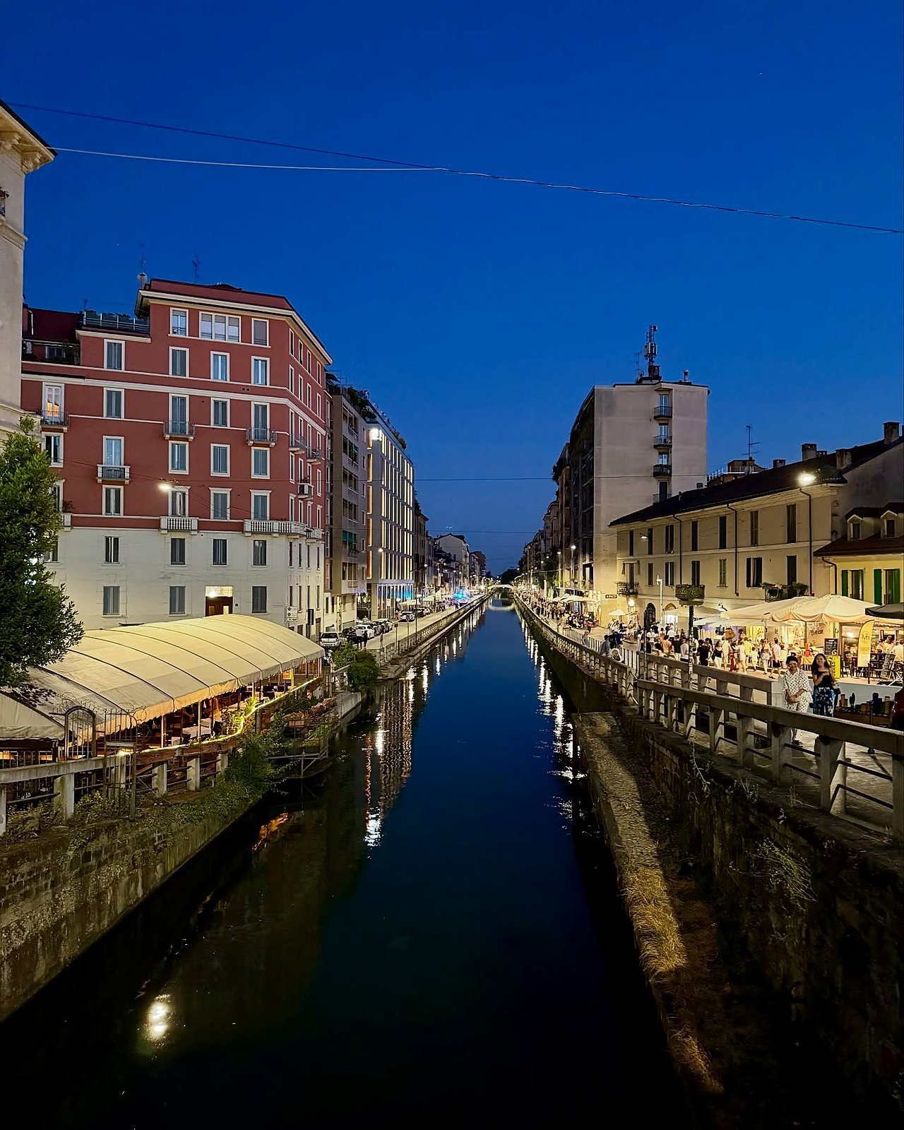 Canal Naviglio Grande em Milão ao anoitecer com bares iluminados nas margens