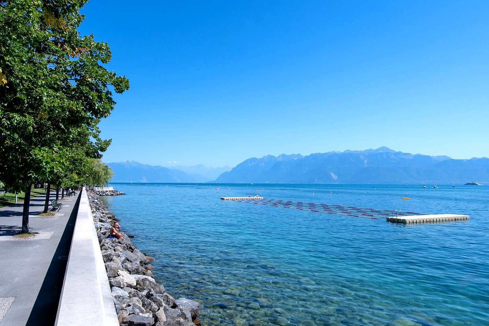 Orla de Ouchy com plataforma de banho no Lago Léman e os Alpes ao fundo