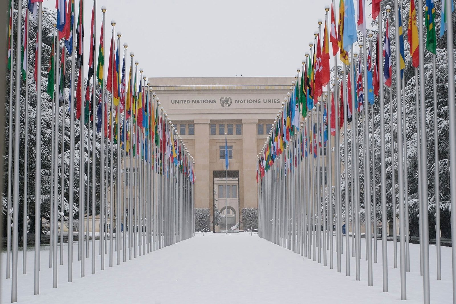 Alameda das bandeiras na entrada do Palácio das Nações, sede da ONU em Genebra, coberta de neve