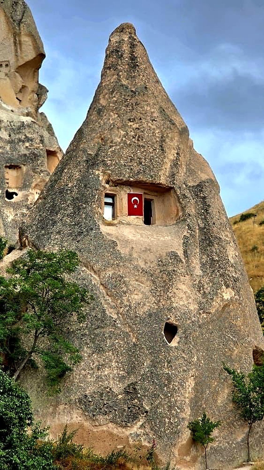 Chaminé de fada com janela e bandeira da Turquia no vale de Paşabağ
