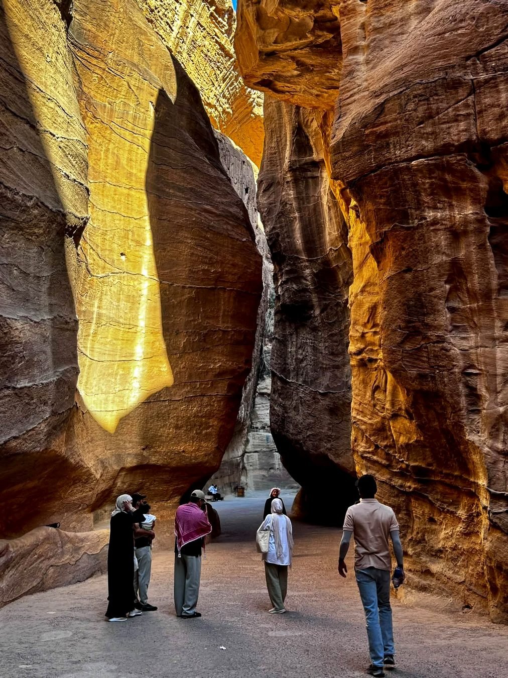 Visitantes caminhando pelo Siq, o cânion estreito que leva a Petra